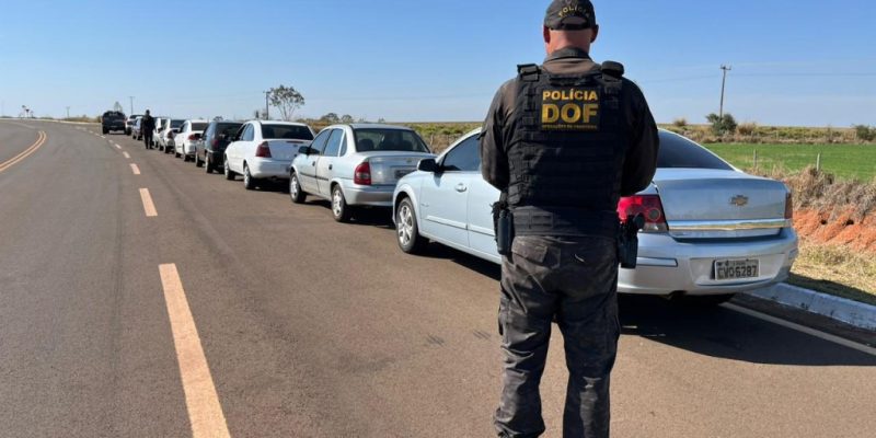 Policial ao lado de comboio apreendido pelo DOF na MS-379 (Foto: DOF/Divulgação)