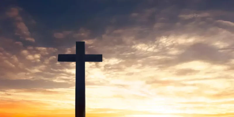 cruz_com_ceu_e_por_do_sol_ao_fundo-821199