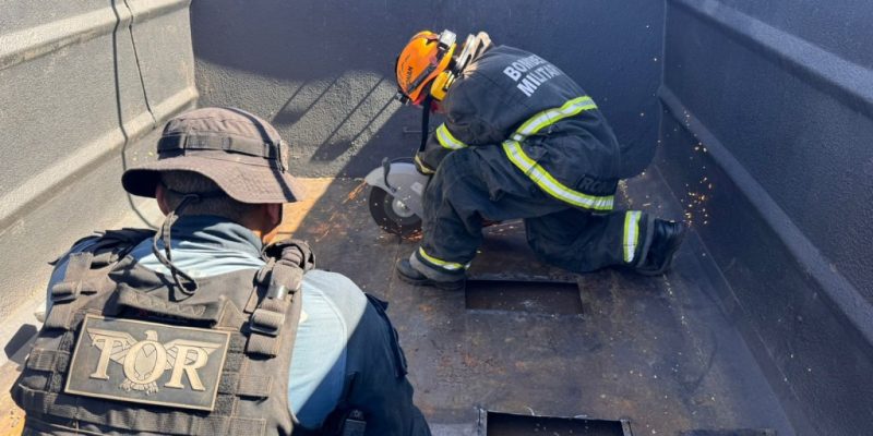 Bombeiro corta assoalho de carreta para retirar tabletes de cocaína (Foto: Divulgação)