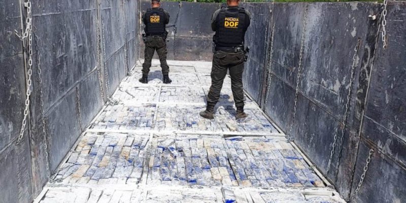Policiais sobre tabletes de maconha encontrados em carreta (Foto: Divulgação)