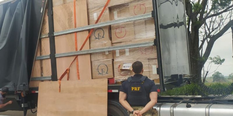 Policial ao lado da carreta lotada de cigarro contrabandeado (Foto: Divulgação/PRF)