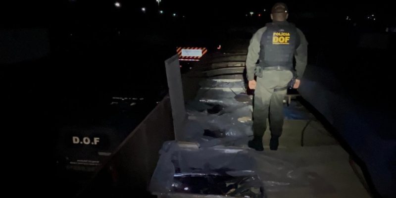 Policial sobre carreta que levava extrato de fruta contrabandeado (Foto: Divulgação)
