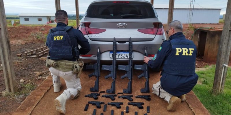 Policiais rodoviários federais ao lado de armas apreendidas hoje na BR-463 (Foto: PRF/Divulgação)