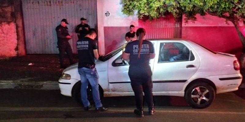 Peritos e policiais militares ao lado do carro (Foto: Leandro Holsbach)