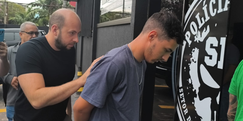 João Victor é conduzido por delegado após ser preso nesta terça-feira (Foto: Leandro Holsbach)