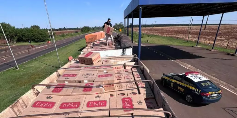 Policial sobre carreta carregada com 40 mil pacotes de cigarro paraguaio (Foto: PRF/Divulgação)