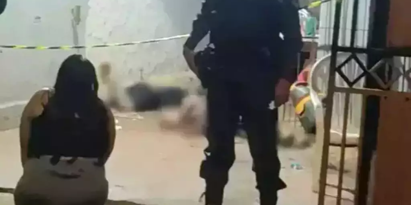 Mulher ajoelhada olhando o filho e o pai mortos dentro de casa (Foto: Direto das Ruas)