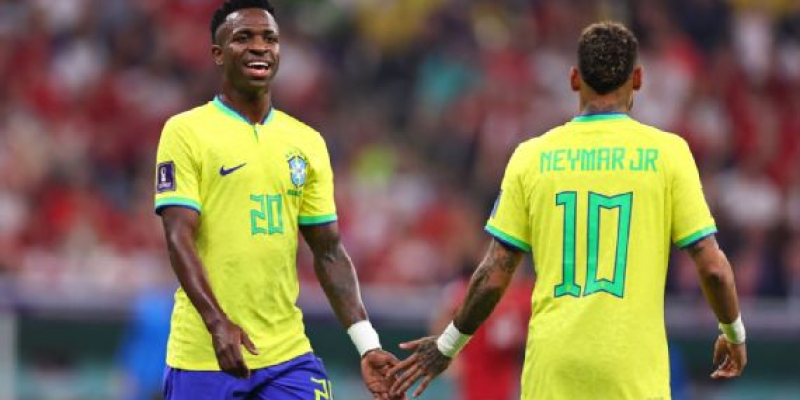 Vini Jr. e Neymar se cumprimentam durante jogo do Brasil na Copa do Mundo Robbie Jay Barratt / Getty Images