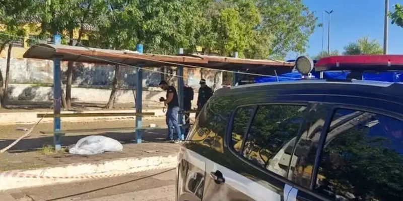 Corpo da vítima coberto por lençol em calçada. (Foto: Diário Corumbaense)