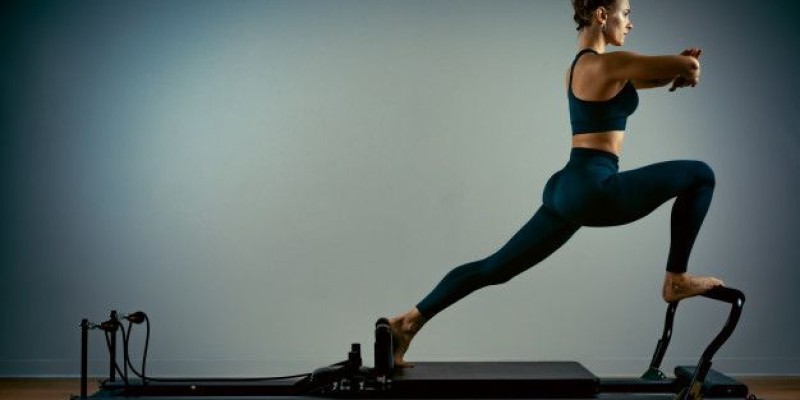 Mulher fazendo pilates exercícios com uma cama de reformador