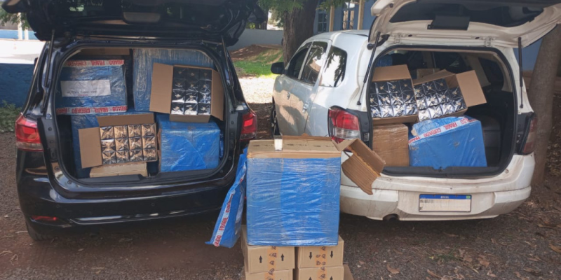 Carros e várias caixas de mercadorias apreendidas com os três homens (Foto: Divulgação/PM)