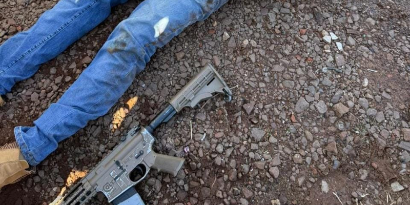 Pistoleiro ferido, caído ao lado de fuzil que usou no atentado (Foto: Divulgação)