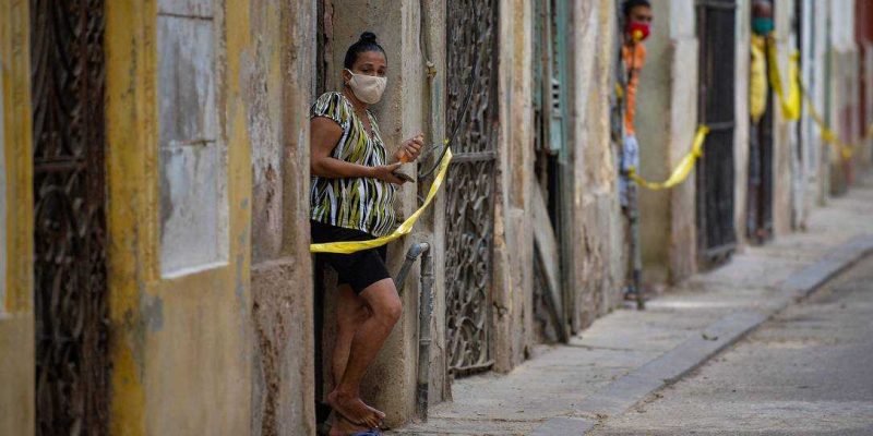 Cubanos nas portas de suas casas em área restrita após avanço de casos de Covid-19 em Havana