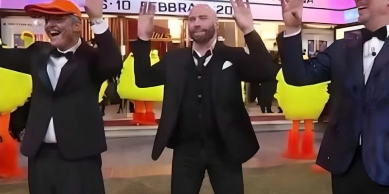 John Travolta fazendo a dança do passarinho durante transmissão de festival de música na Itália