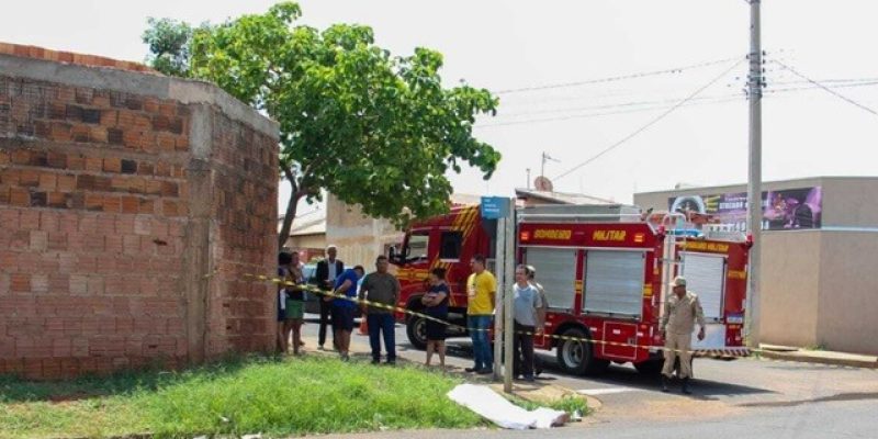 Corpo de Reinalda coberto por lençol no local onde caiu após acidente (Foto: Juliano Almeida)