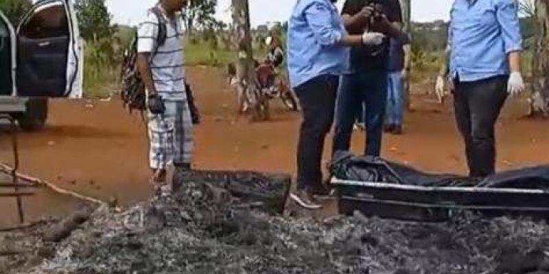 Corpos sendo recolhidos entre cinzas de barraco (Foto: Reprodução)