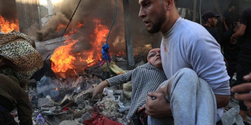 Palestino socorre garota gravemente ferida depois de bombardeio israelense em Rafah, no sul da Faixa de Gaza
(foto: Said Khatib/AFP)