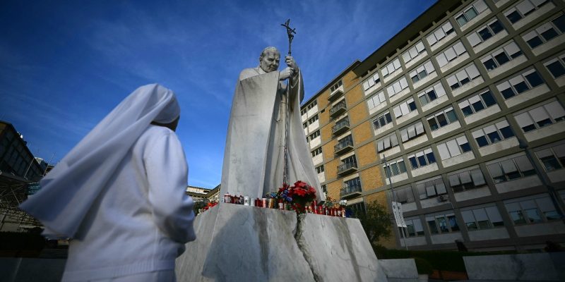 Fiéis fazem vigília e acendem vela na porta de hospital em Roma