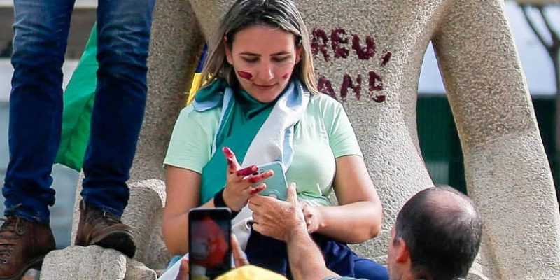 Débora Rodrigues dos Santos flagrada por fotógrafos escrevendo a frase “Perdeu, mané” na estátua da Justiça