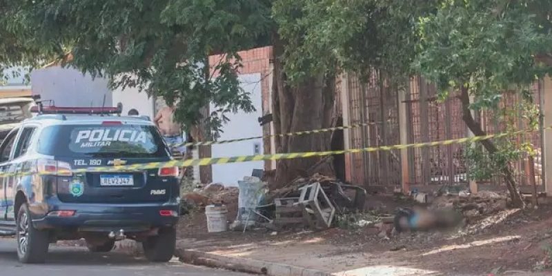 Mulher caída na calçada da casa e local sendo preservado pela Polícia Militar (Foto: Marcos Maluf)