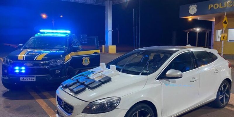 Tabletes de skunk sobre o capô do Volvo; douradense foi preso (Foto: PRF/Divulgação)